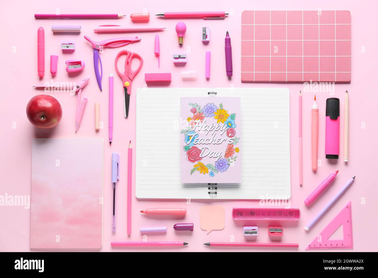 Teacher's Day concept. School supplies and greeting card on pink