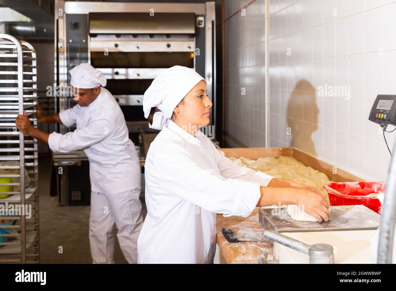 baker weighing bread dough on scale at bakery Stock Photo - Alamy