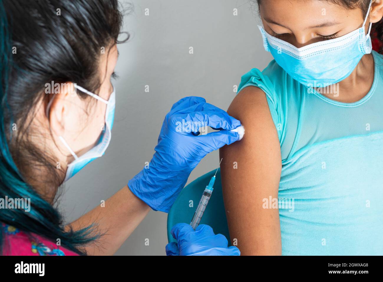 children's nurse wiping blood with cotton wool after administering