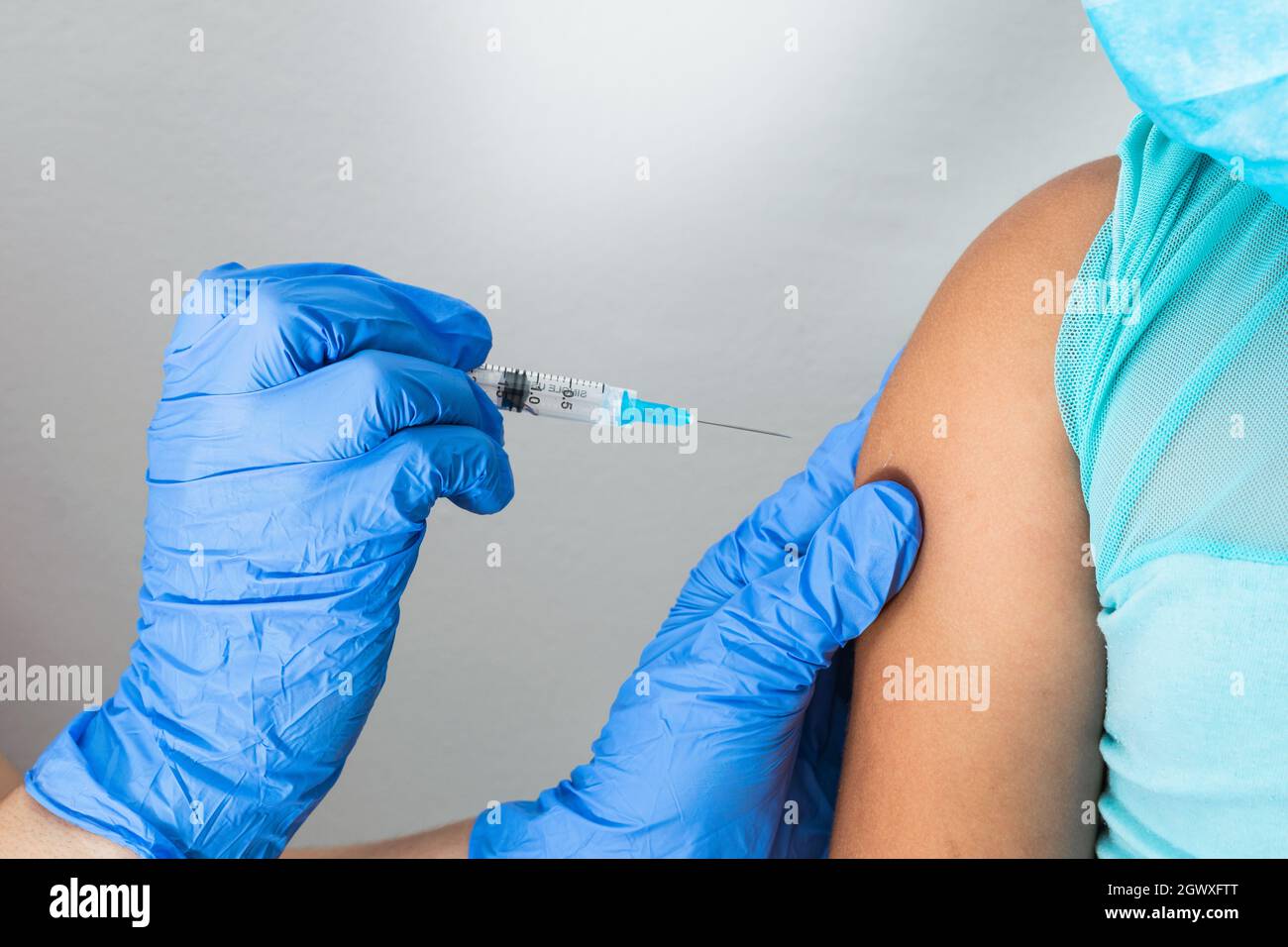 children's nurse about to administer the injection into the arm of a little brown girl. doctor injecting covid-19 vaccine. flu vaccine. medical concep Stock Photo