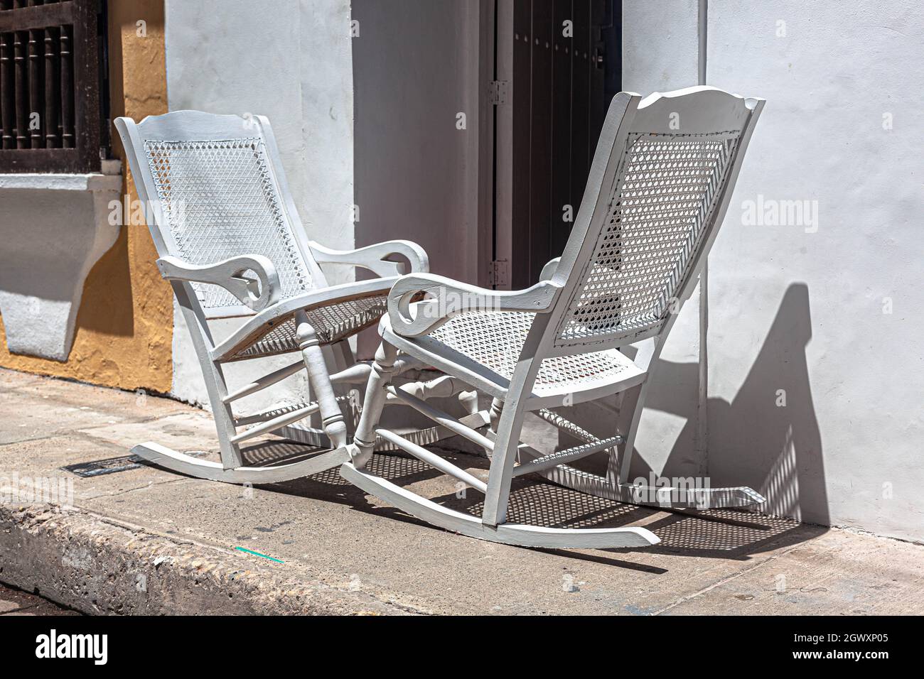 Two wooden rocking chairs on a pavement, just outside a Republican colonial house, Cartagena de Indias, Colombia. Stock Photo
