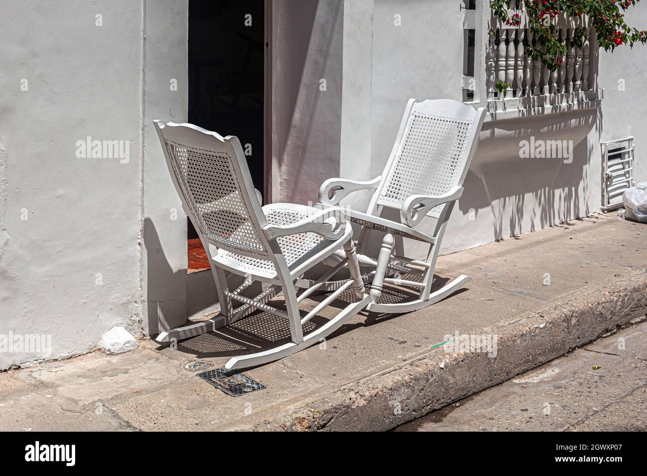 Two wooden rocking chairs on a pavement, just outside a Republican colonial house, Cartagena de Indias, Colombia. Stock Photo