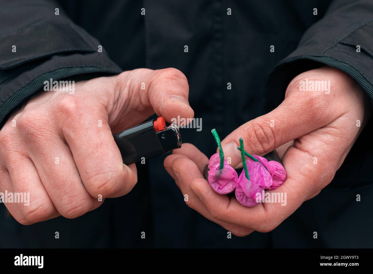 Midsection Of Person Holding Lighter And Bomb Stock Photo - Alamy