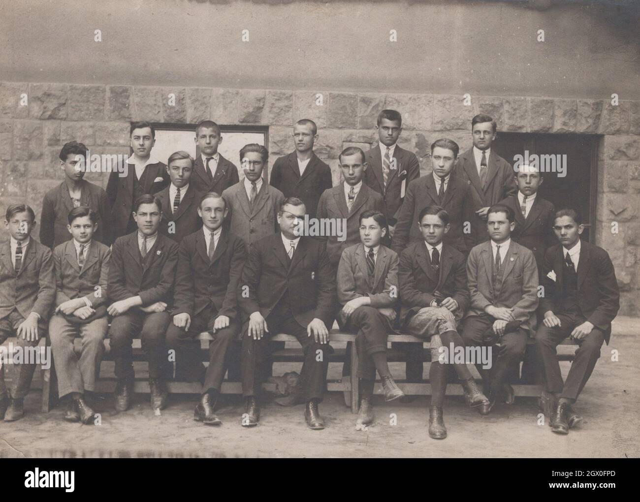 super rare vintage photo from the 1930's a Boys school class is visible at this photo. They are approximately 14-15 years old. Them teacher ( who is very dignified person blind in one eye) has got only one eye. He is a monocular or one-eyed person who has got a order of valor, or in hungarian order of Vitez medal. This medal was quite honorable at the Horthy's regime in Hungary. Period: 1930's Source: original photograph Stock Photo