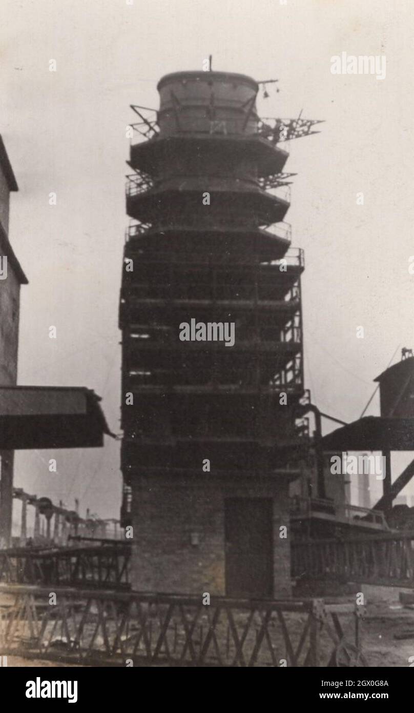 original vintage photograph from the 1920'S OR 1930'S. This is a construction site where a tower or skycraper is rising from the ground. There are scaffolding around everywhere, because safety first was the slogen always. source: original photograph. Stock Photo