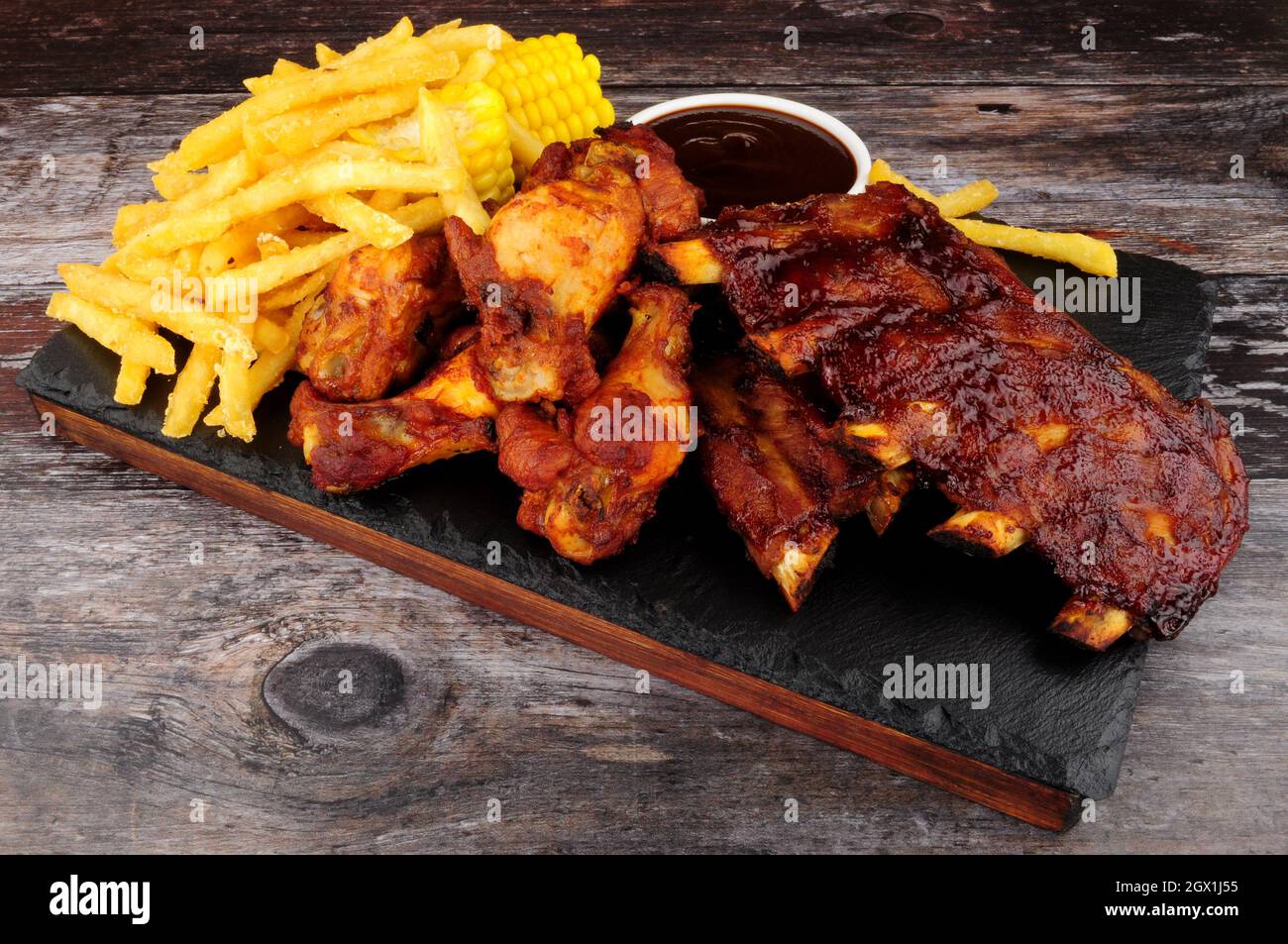 Barbecue pork ribs and chicken wings with French fries and sweetcorn on the cob Stock Photo Alamy