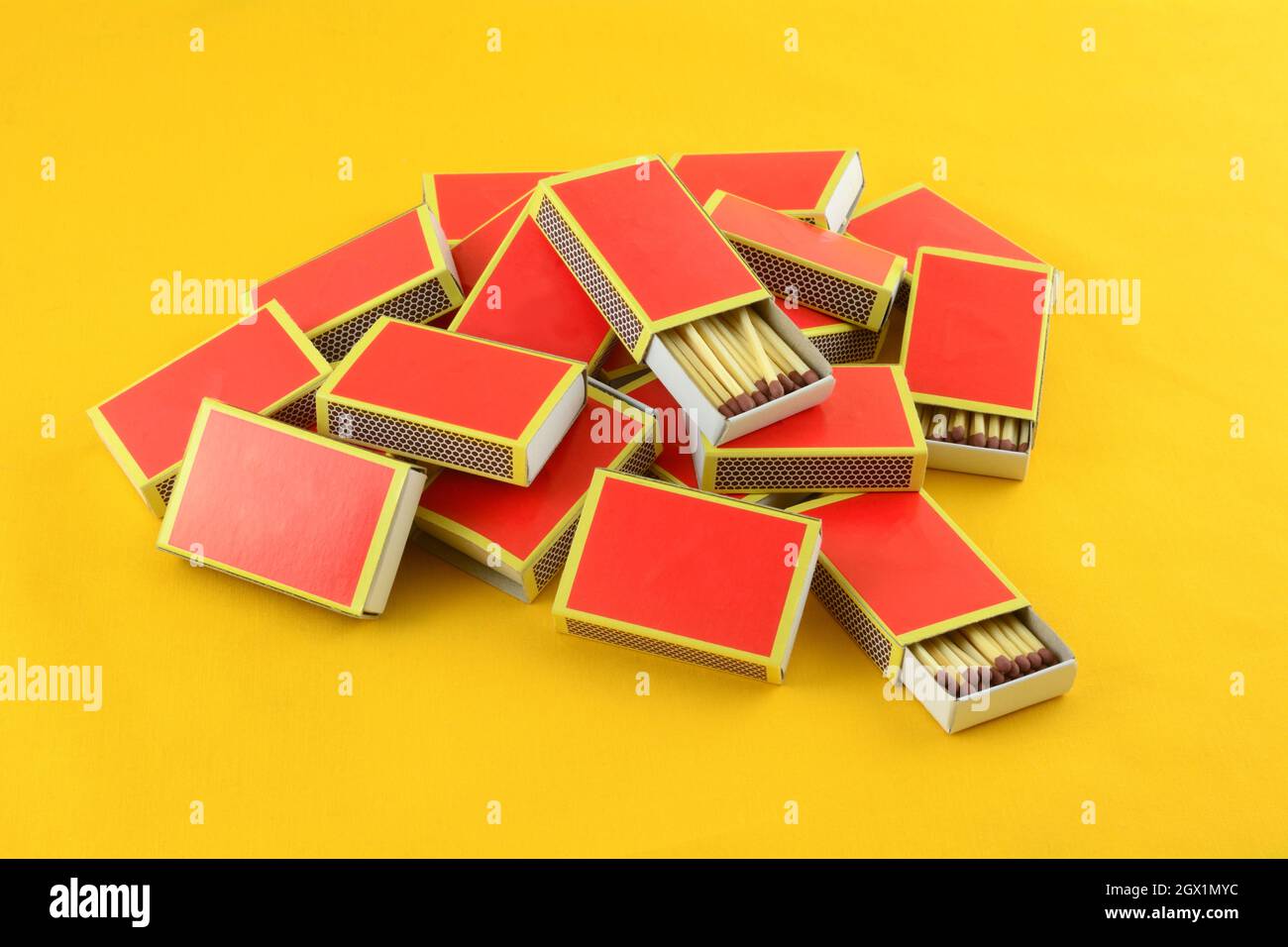 Heap of red boxes of safety matches with two open on yellow background Stock Photo