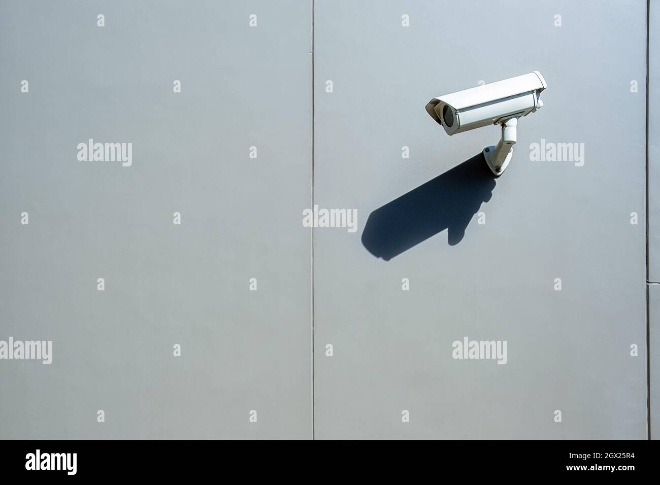 Surveillance Wall Mounted Outdoor Camera With Harsh Daylight Shadow And Copy Space Stock Photo