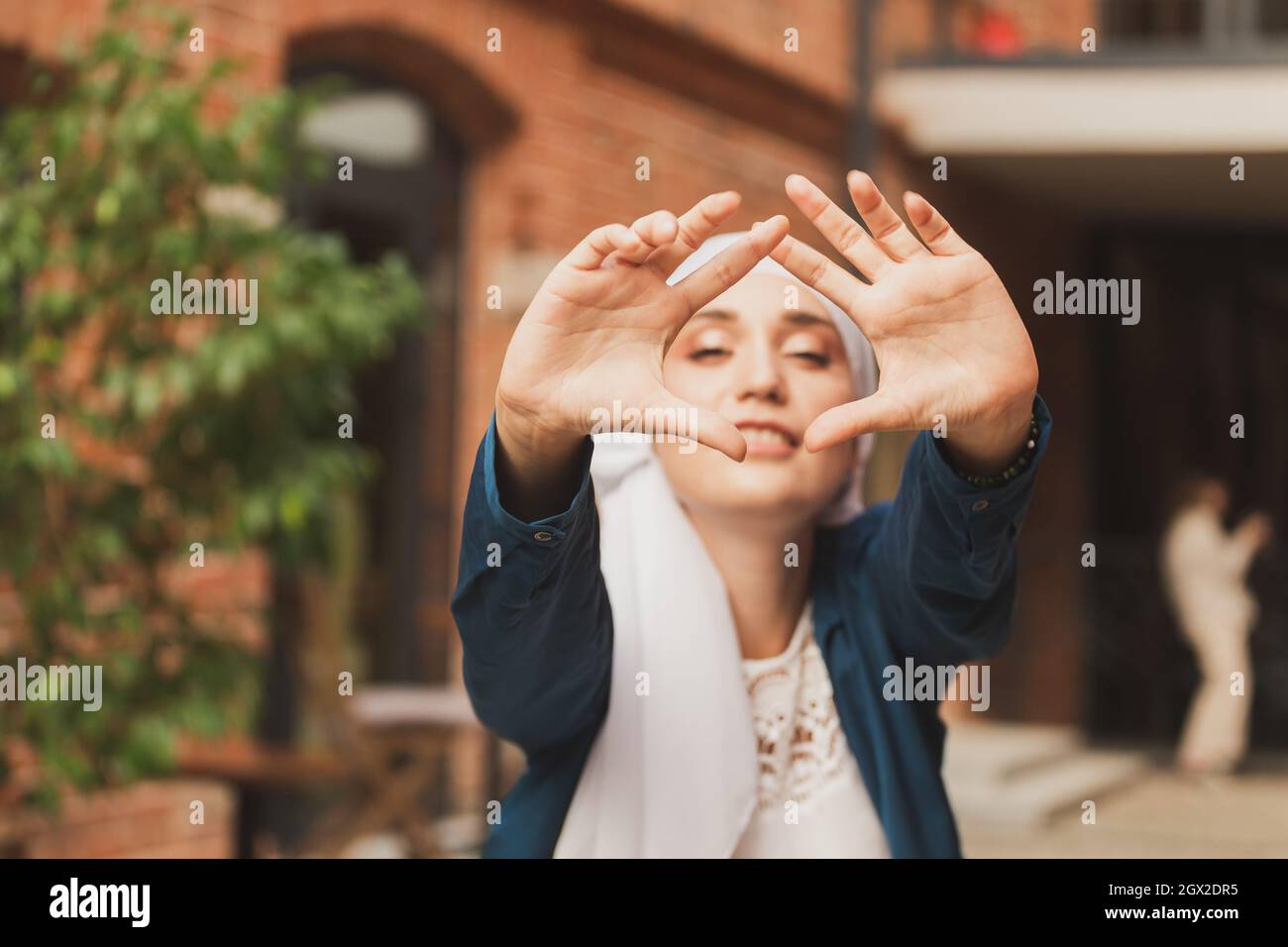 Portrait of young muslim woman wearing hijab head scarf in city while ...