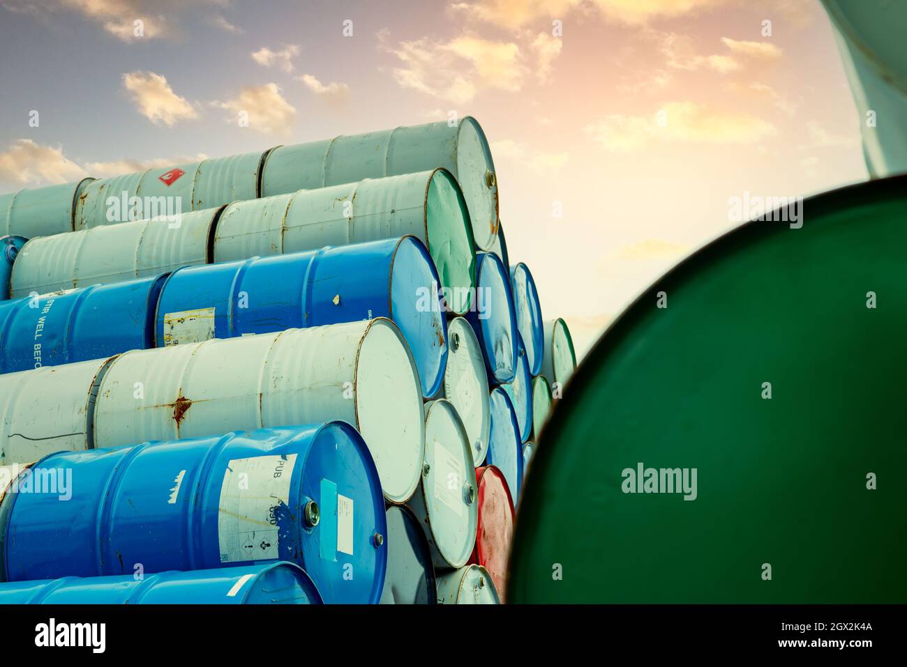 Old chemical barrels stack. Red, green, and blue chemical drum. Steel tank of flammable liquid. Hazard chemical barrel. Industrial waste. Empty Stock Photo