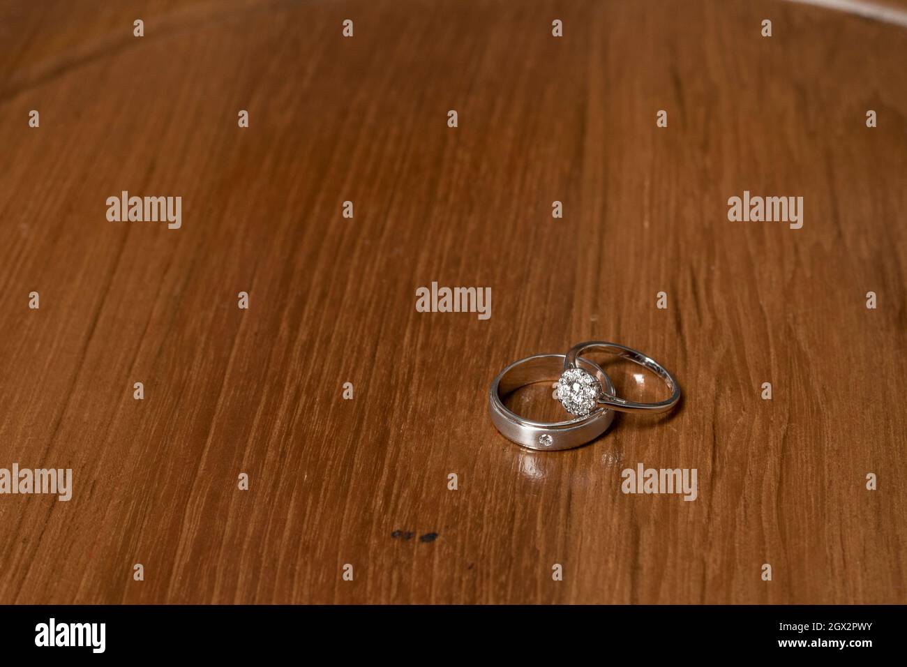 Close-up Of Wedding Rings On Wooden Table Stock Photo