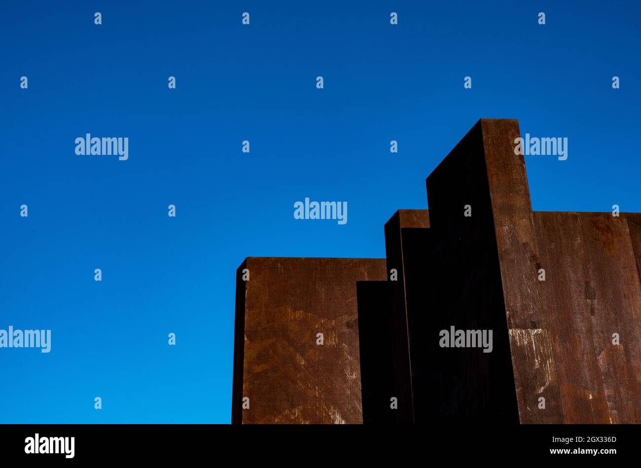 Low Angle View Of Stained Wall Against Clear Blue Sky Stock Photo