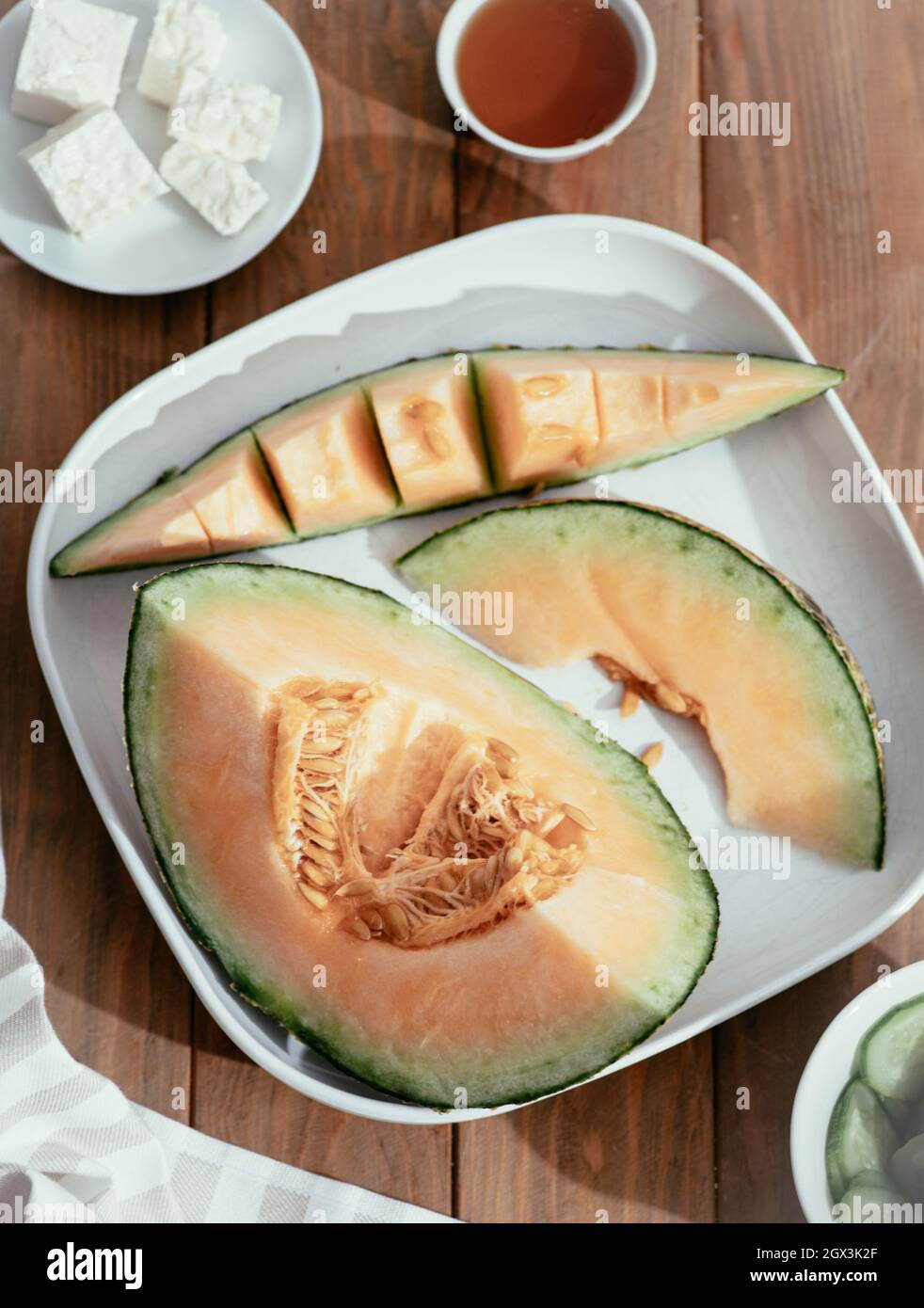 Fresh melons sliced on wooden table. Free space for text. Top view. Melon sliced of Japanese melons,honey melon or cantaloupe Cucumis melo on wooden t Stock Photo