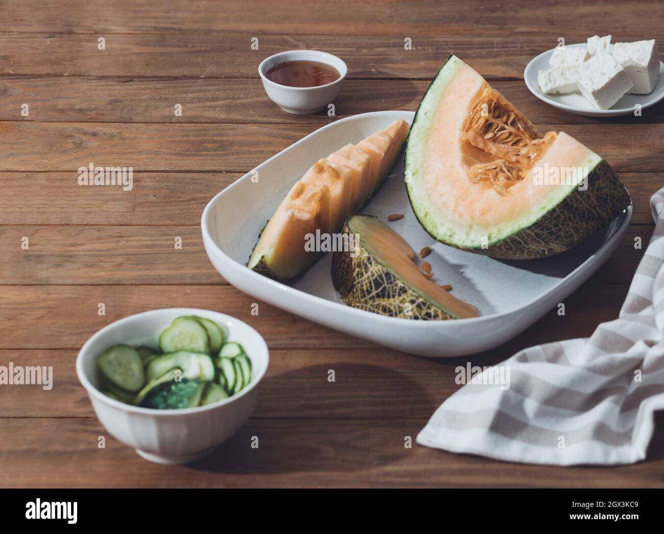 Fresh melons sliced on wooden table. Free space for text. Top view. Melon sliced of Japanese melons,honey melon or cantaloupe Cucumis melo on wooden t Stock Photo