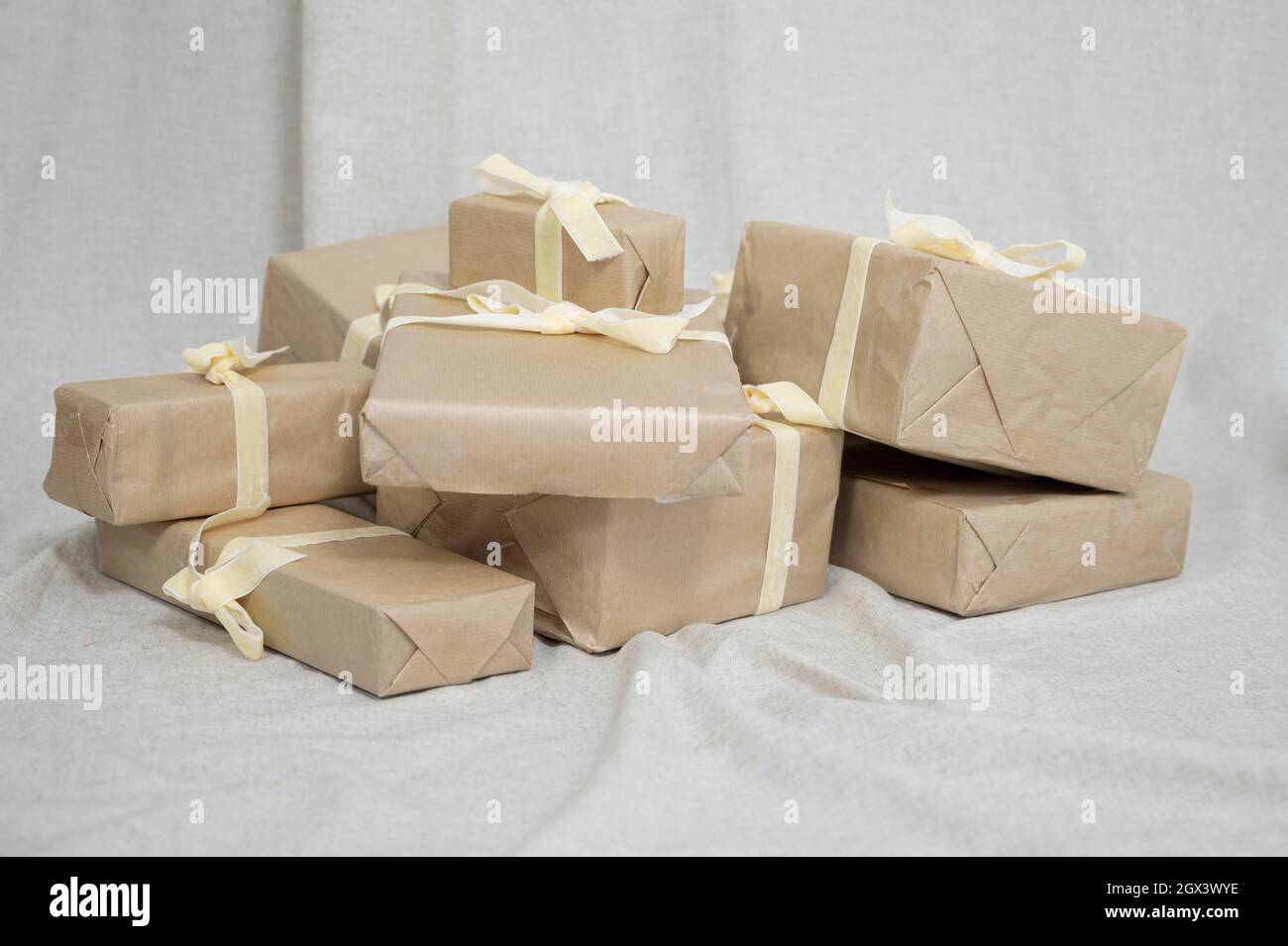 Bunch of Christmas gifts in boxes wrapped in brown kraft paper and tied ...