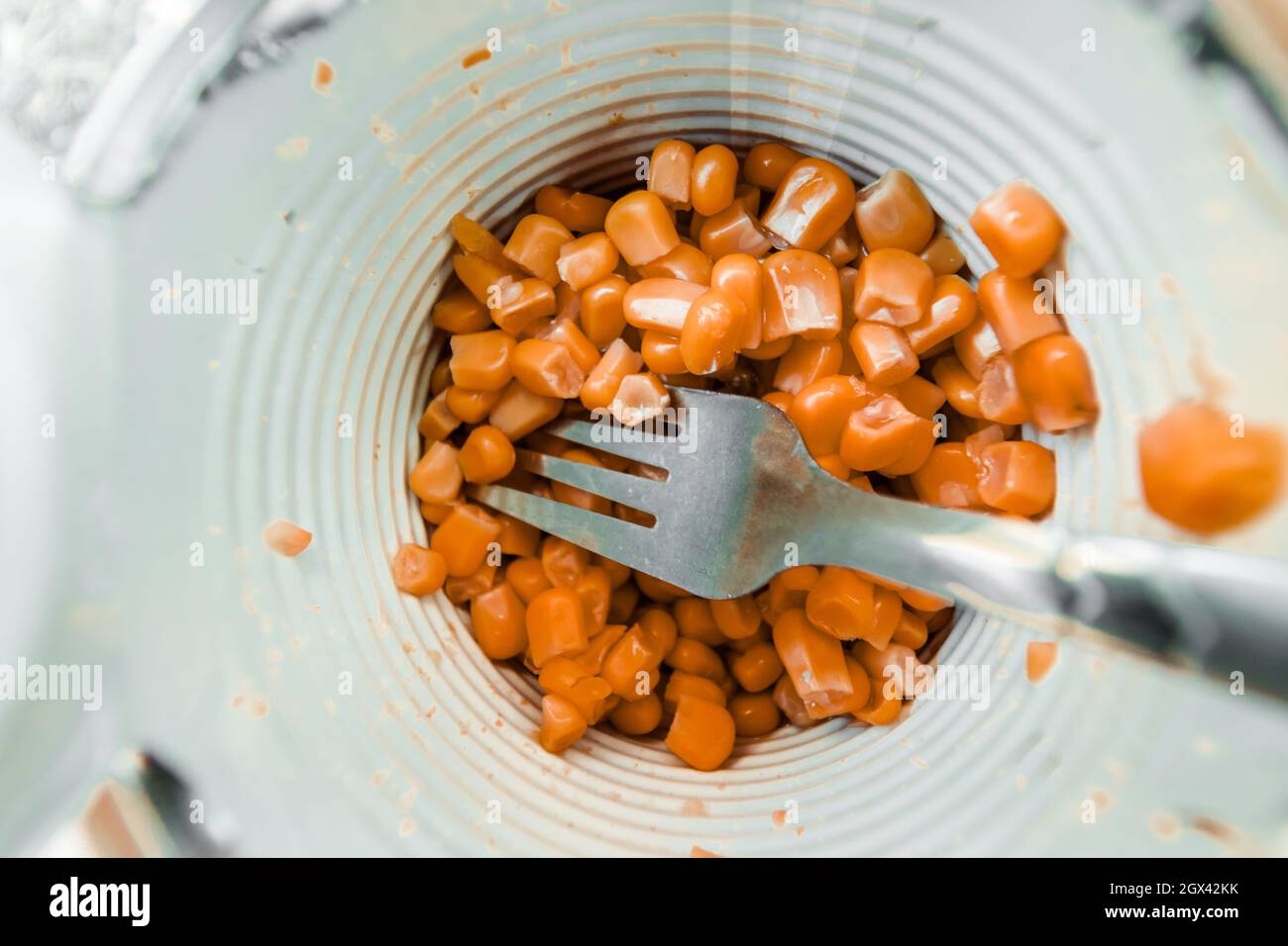 Canned corn in a jar with a fork close-up. Stock Photo