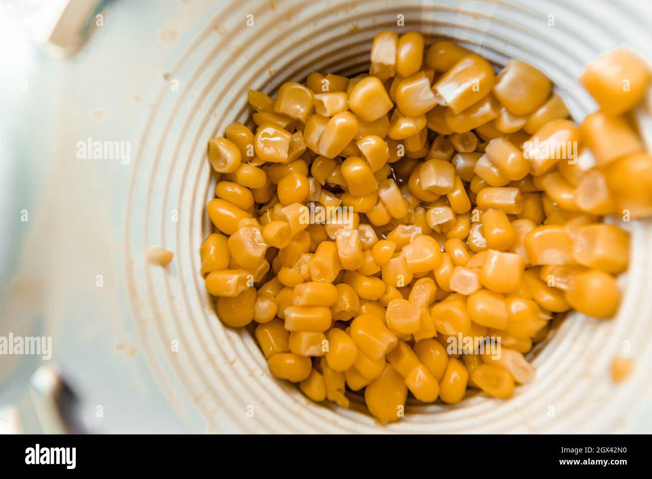 Lots of canned corn in an aluminum can. Close-up top view. Stock Photo