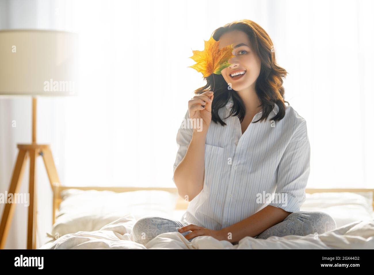 Happy young woman enjoying sunny morning on the bed Stock Photo - Alamy