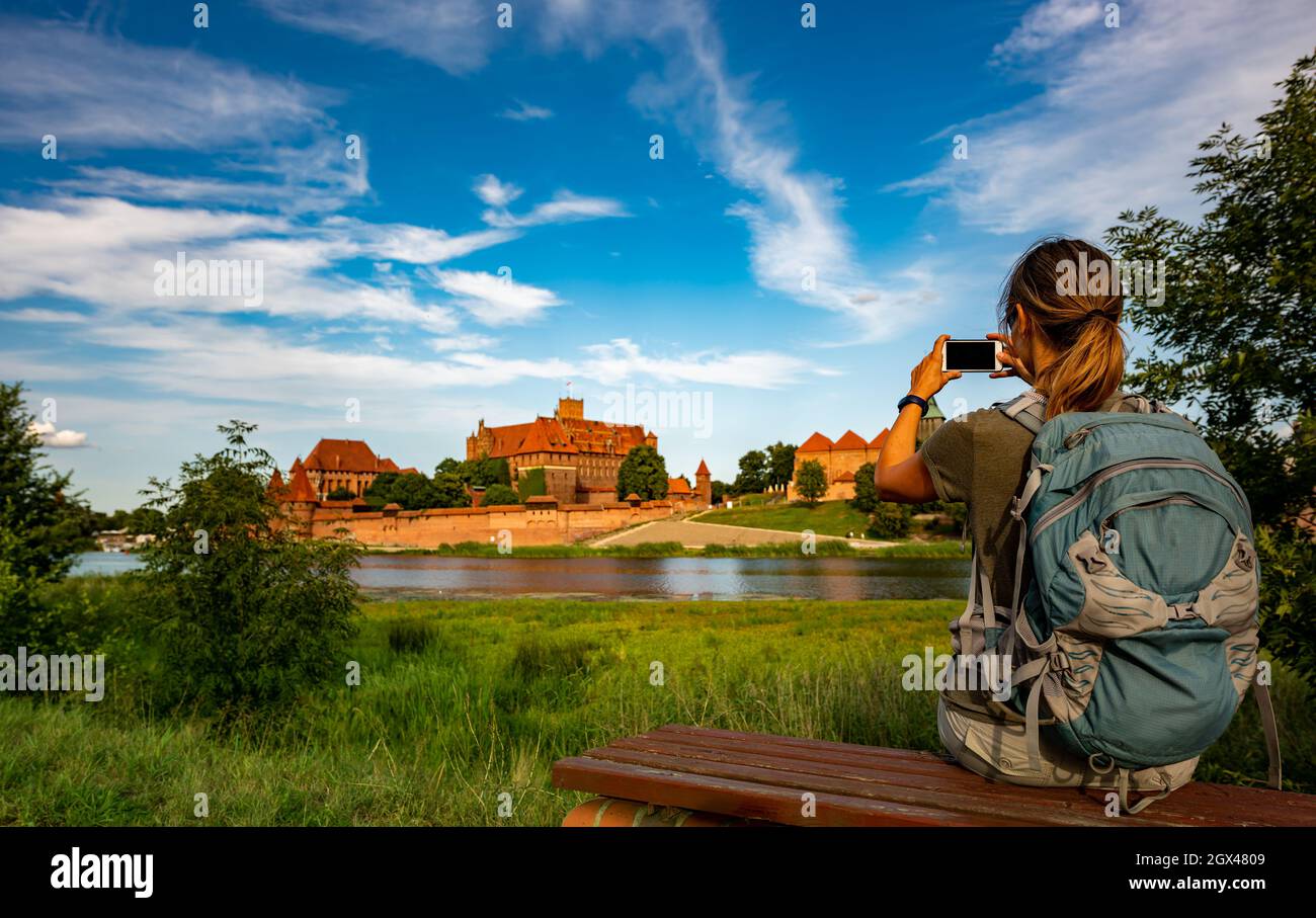 Visiting Poland Tourist takes photo of famous Malbork Castle Stock Photo