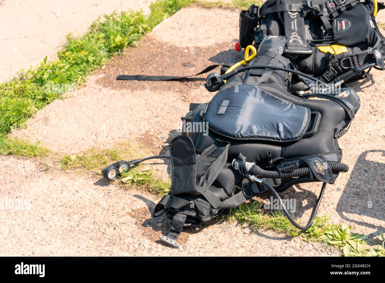 BSD vests - buoyancy compensators with snorkel and diving devices lie on a concrete slab on a sunny summer day. Stock Photo
