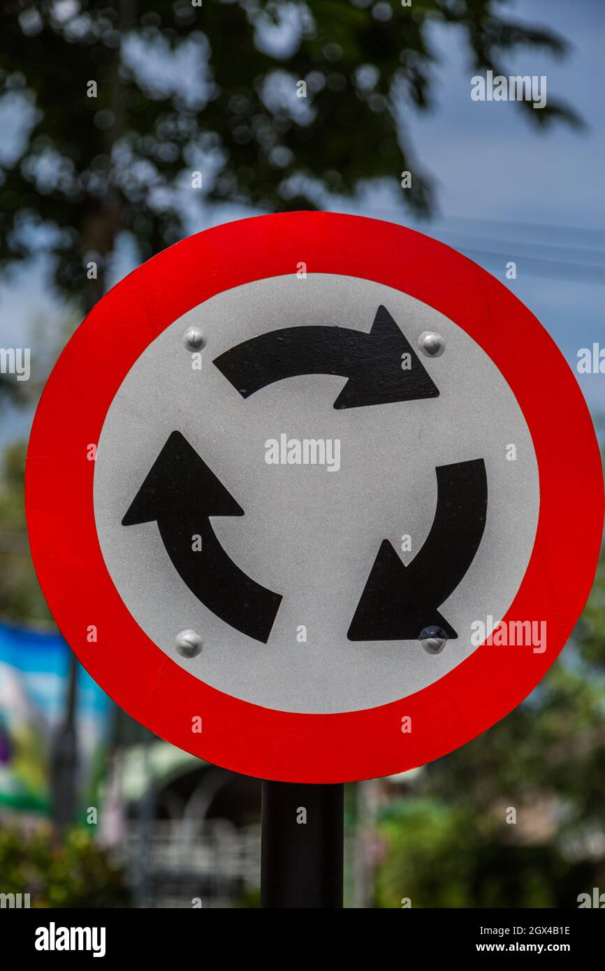 Roundabout Road Sign for Traffic with green bokeh background Stock