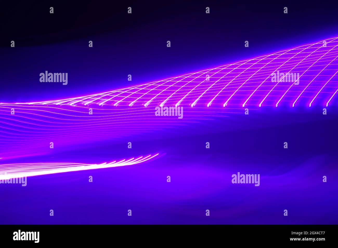 Neon pink light trails twisting tunnel pattern Stock Photo