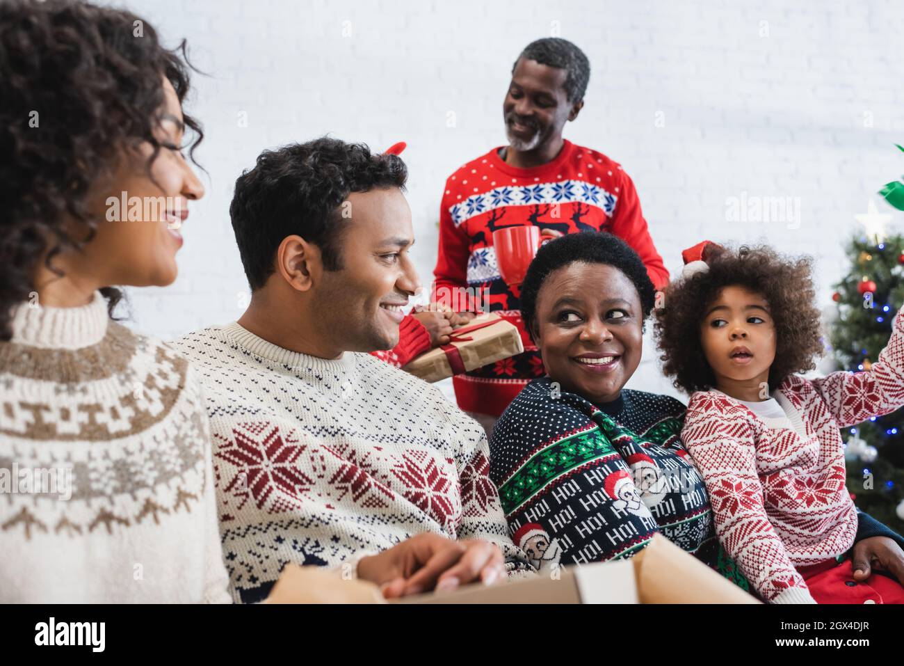 african american family smiling while talking in living room Stock Photo