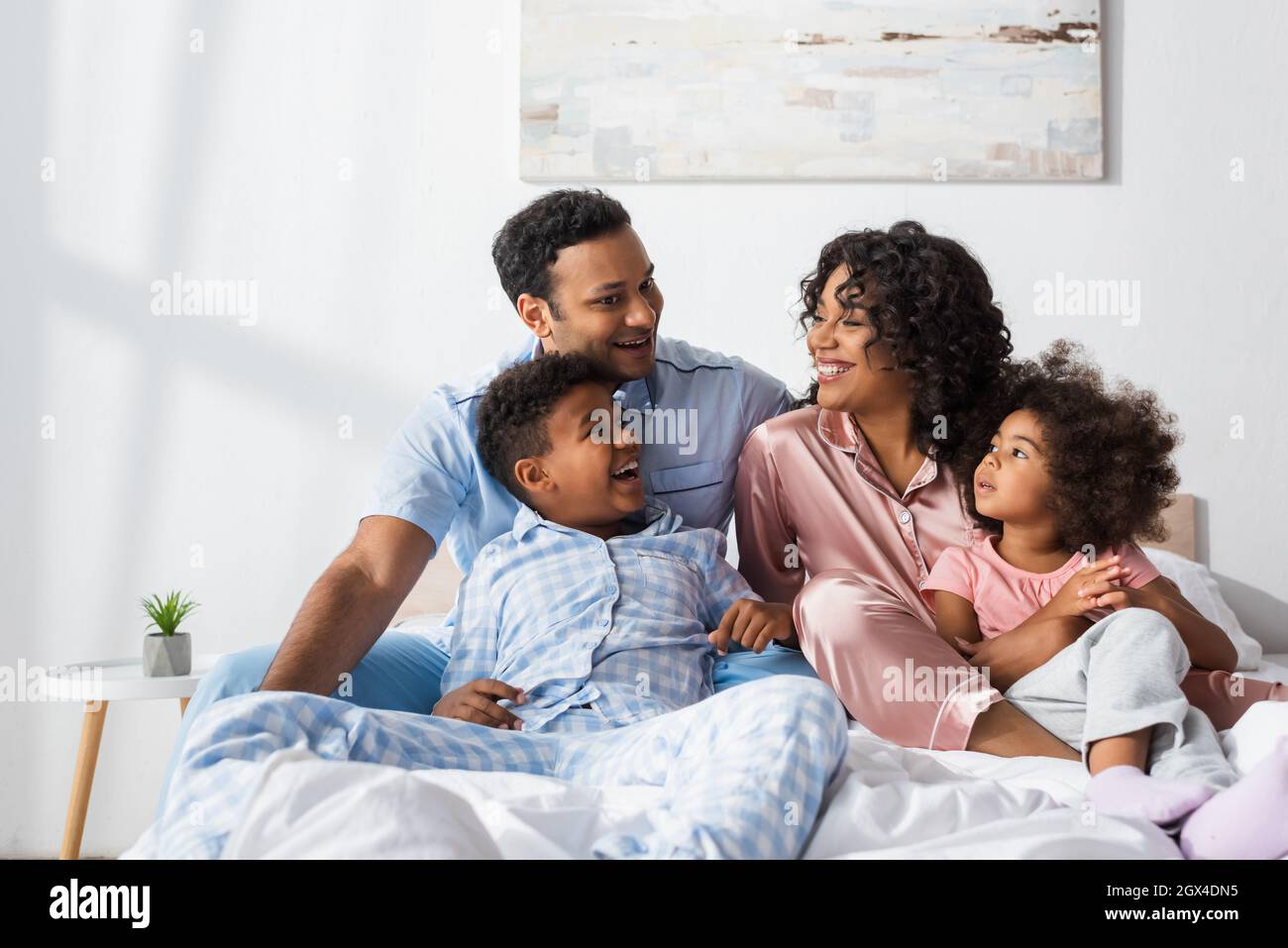 happy african american couple talking in bed near cheerful kids Stock Photo