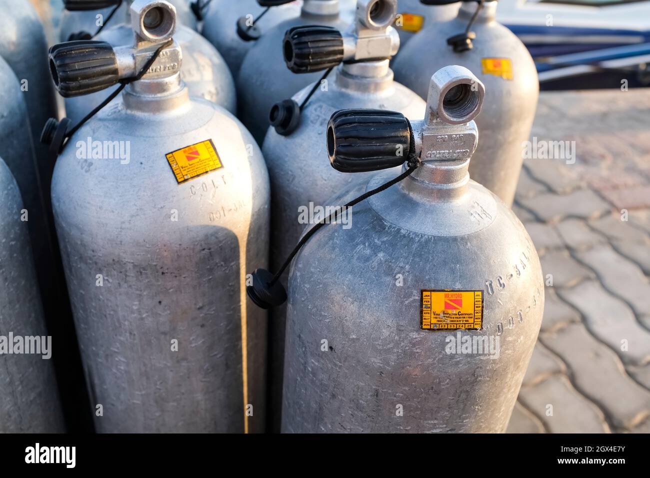 A lot of aluminum scuba diving oxygen tanks standing in front of the
