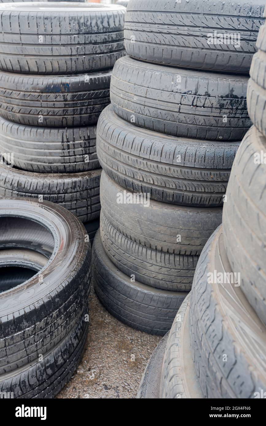 Old and worn out motor vehicle car tyres (tires) stacked and waiting to be disposed of or recycled in Sydney, Australia Stock Photo