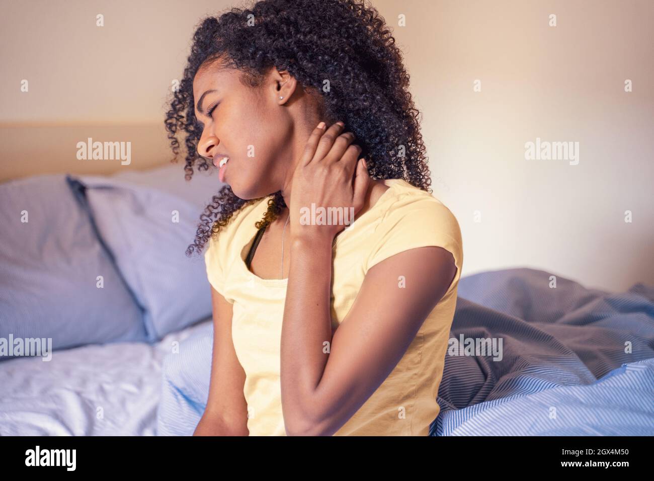 Black woman in bed suffering neck pain Stock Photo Alamy