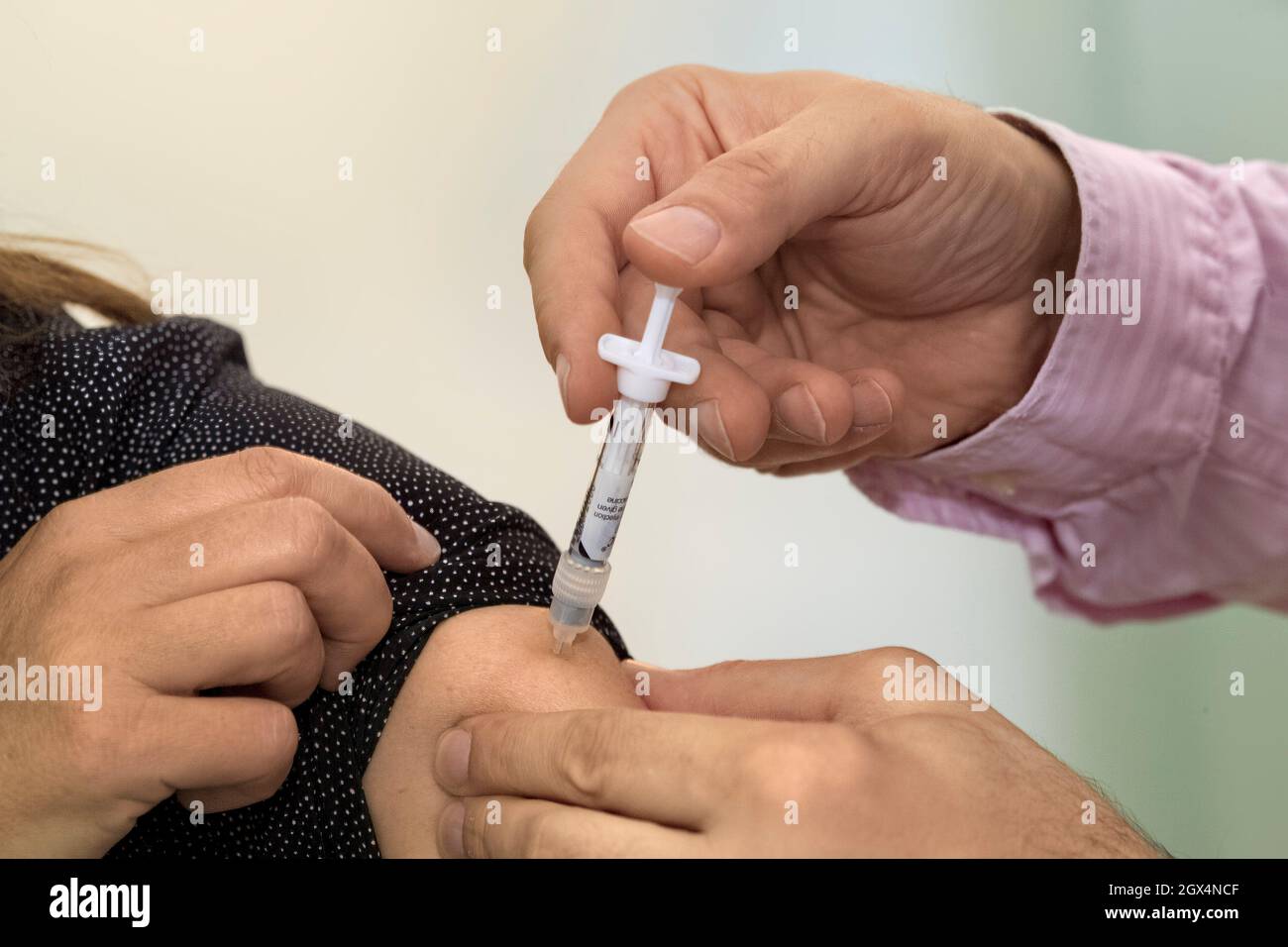 Influenza vaccination as an injection in the upper arm. Stock Photo