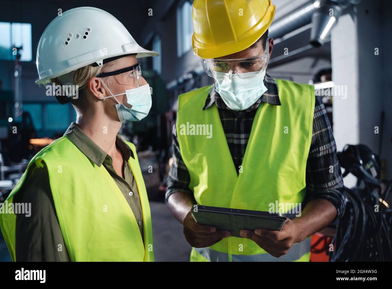 Portrait of industrial inspectors with face masks doing a general check ...