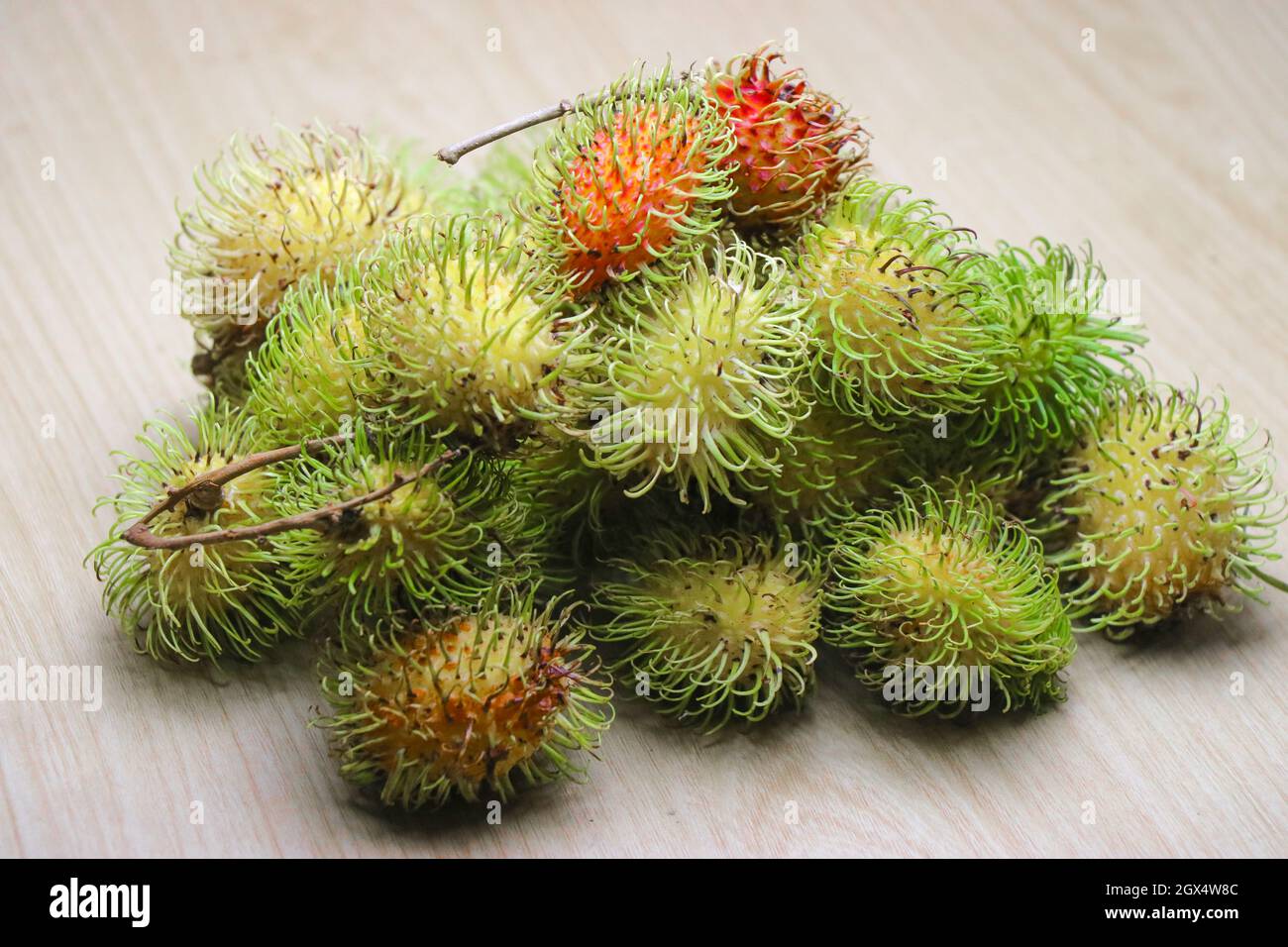 Rambutan which is a tropical fruit on wooden background with ripe and ...