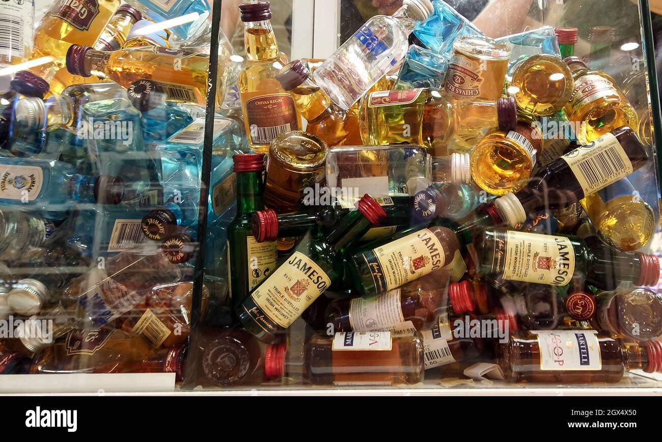 collectible mini bottles of alcohol at the duty free market shop. Little alcohol drinks in glass box. Bodrum, Turkey - September 14, 2021 Stock Photo