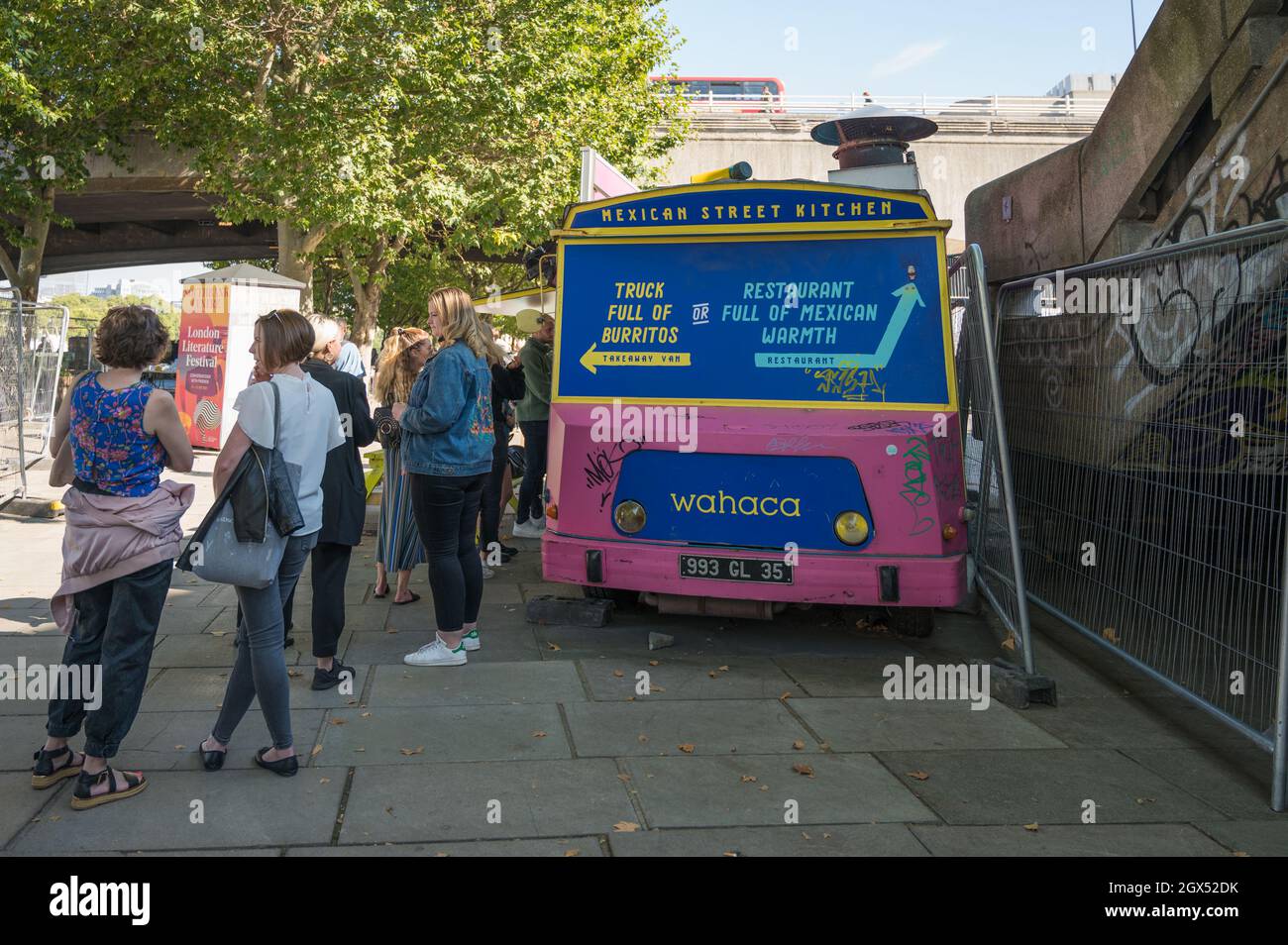 People queueing to buy Mexican food from Wahaca mobile Mexican Street Kitchen food van, South Bank, London, England, UK Stock Photo