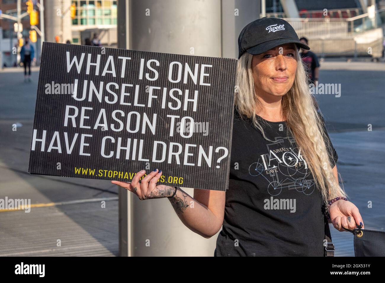Supporter of the 'Stop Having Kids' movement with signs in the Yonge-Dundas Square in the downtown district of Toronto city, Canada. Stock Photo
