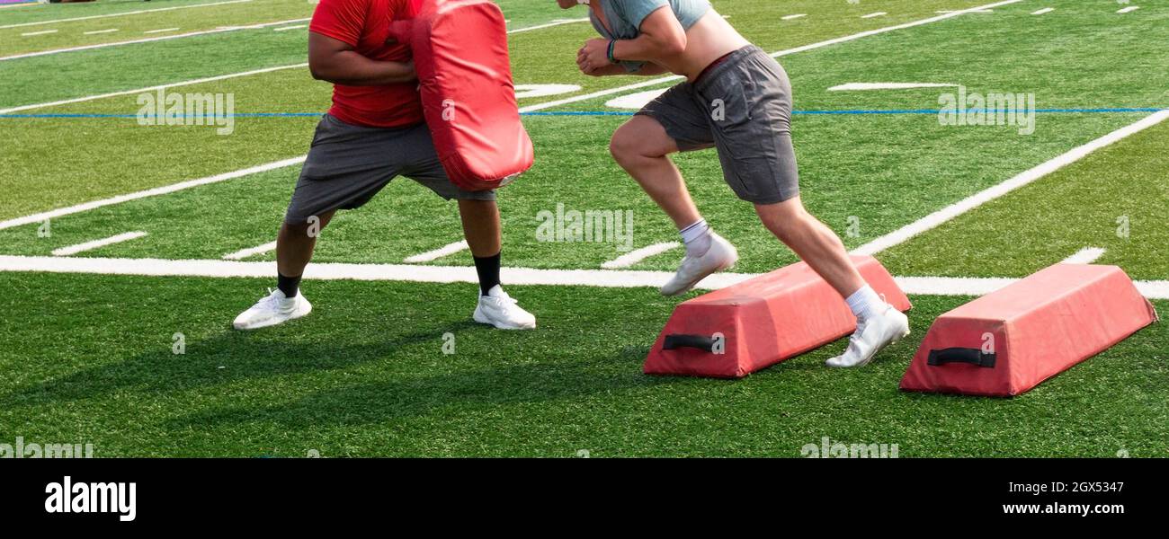 High schooll football player avoiding red barriers and hitting the