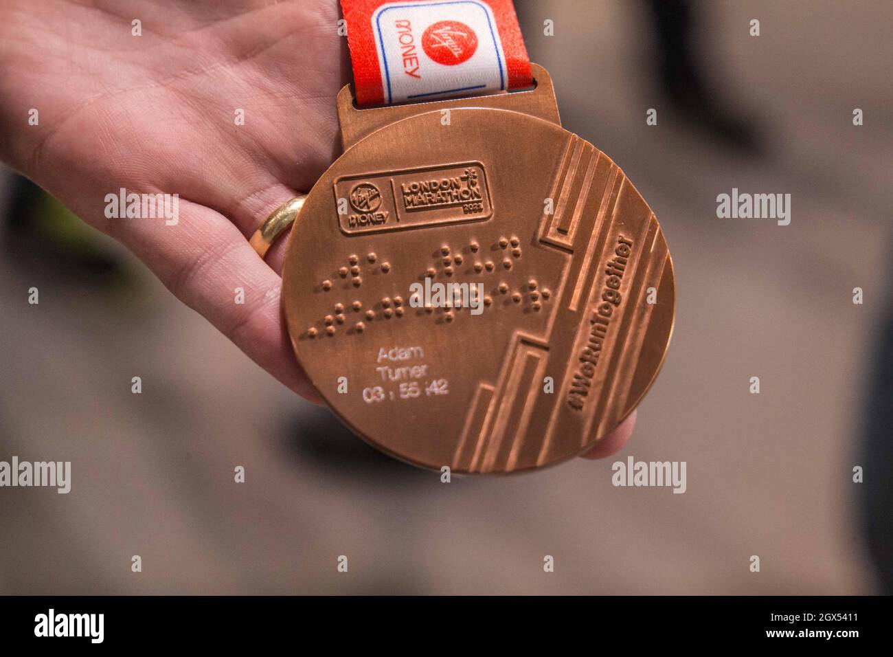 London UK 4 October 2021 Adam Turner showing his London Marathon winners  medal with his name engraved as well as time of 3:56:42 completion to the  race,Service been offered by New balance