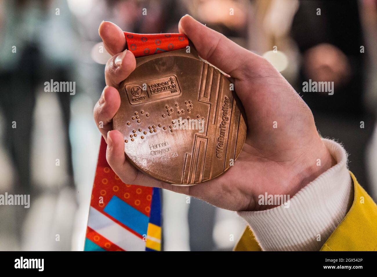 People queuing to get marathon medals winners engraved hires stock