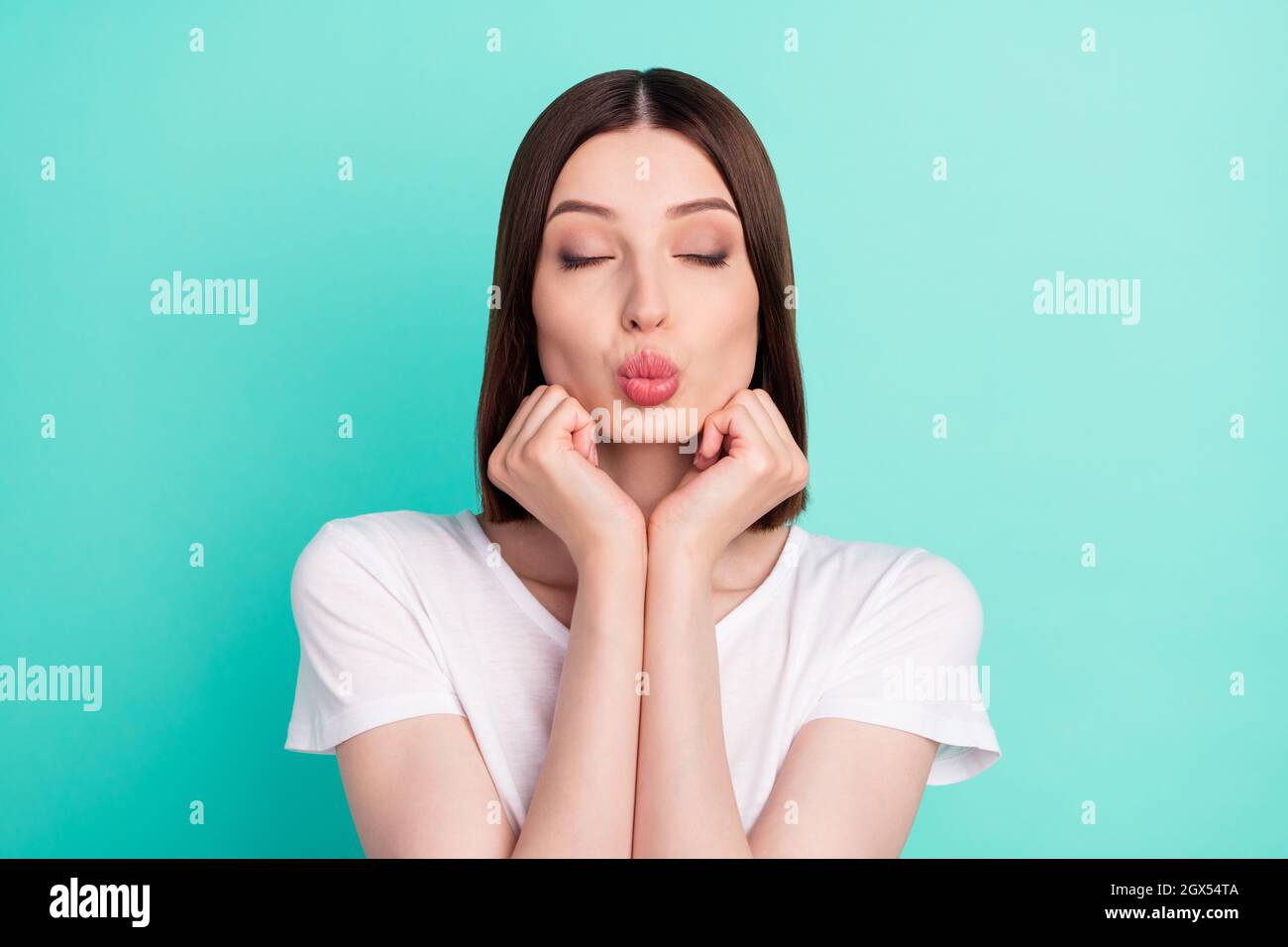 Photo of brunette hair flirty lady blow kiss wear white t-shirt isolated on teal color background Stock Photo