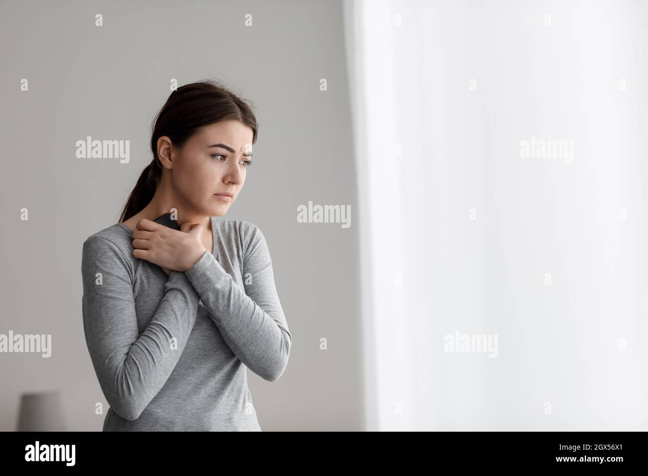 Despaired unhappy caucasian young lady hugging her phone to chest after bad news or breakup Stock Photo