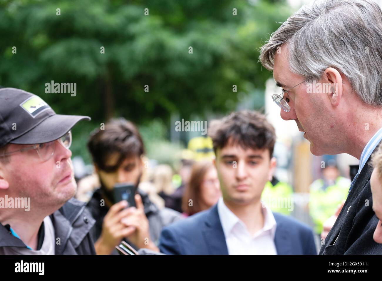 Manchester, UK – Monday 4th October 2021 – Conservative MP Jacob Rees-Mogg speaks to a disabled man who says he lost his job because of the Tories - outside the Conservative Party Conference in Manchester. Photo Steven May / Alamy Live News Stock Photo
