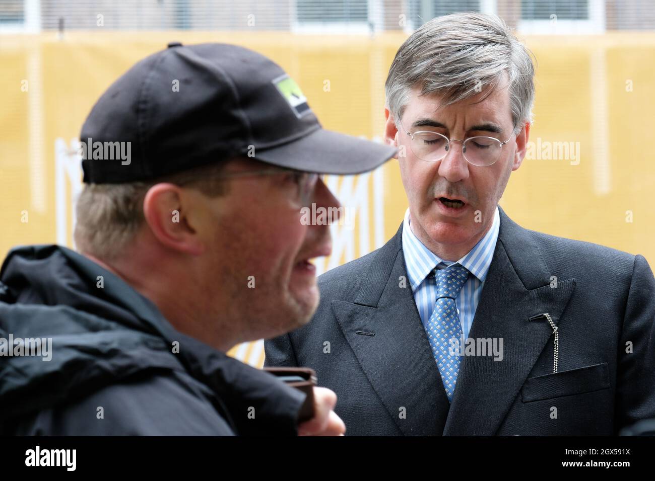 Manchester, UK – Monday 4th October 2021 – Conservative MP Jacob Rees-Mogg speaks to a disabled man who says he lost his job because of the Tories - outside the Conservative Party Conference in Manchester. Photo Steven May / Alamy Live News Stock Photo