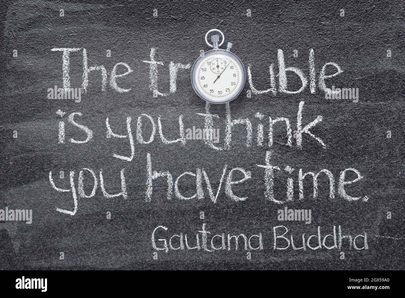 The trouble is you think you have time - quote of Gautama Buddha written on chalkboard with stopwatch symbol instead of O Stock Photo