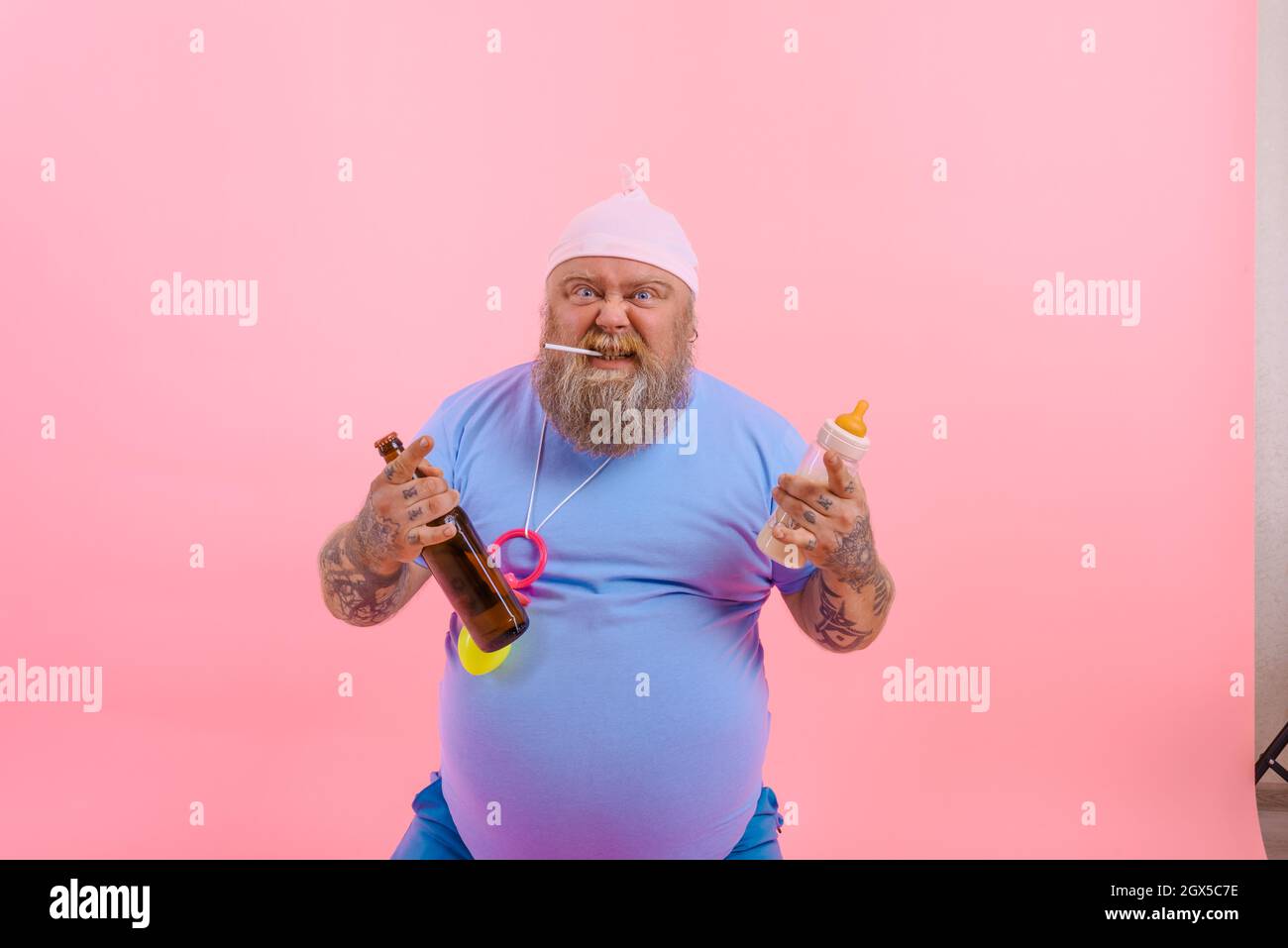 Fat angry man acts like a angry baby but drinks beer Stock Photo