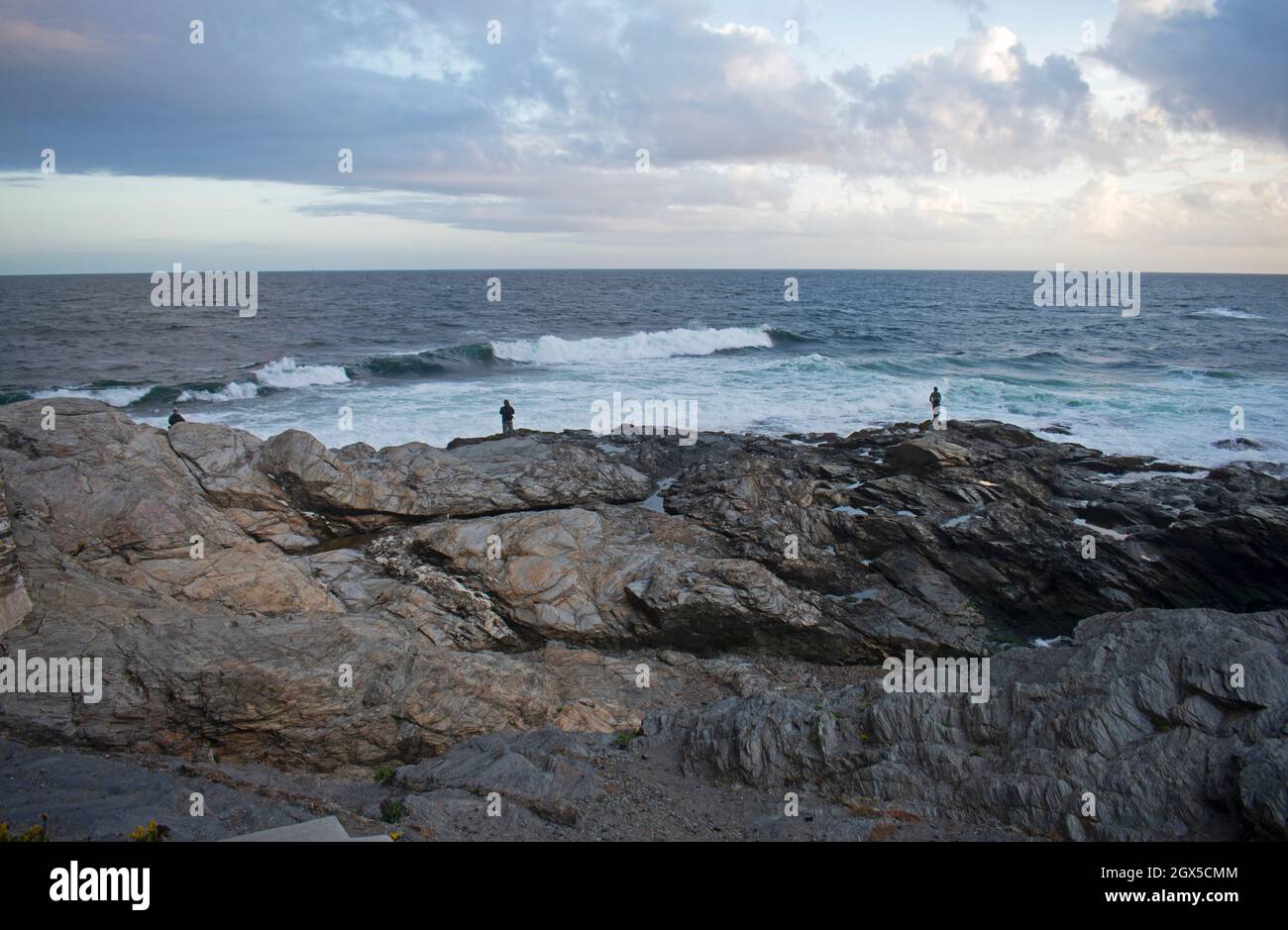 Fishermen fishing on rocky shore in Jamestown, Rhode Island as waves crash into shore -03 Stock Photo