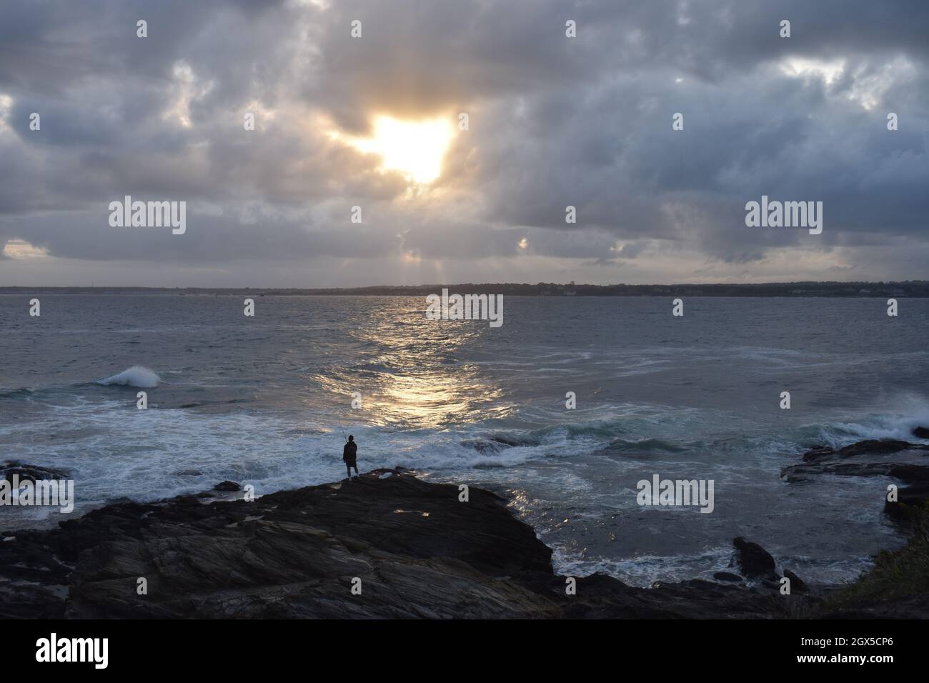 Fishermen fishing on rocky shore in Jamestown, Rhode Island as waves crash into shore -02 Stock Photo