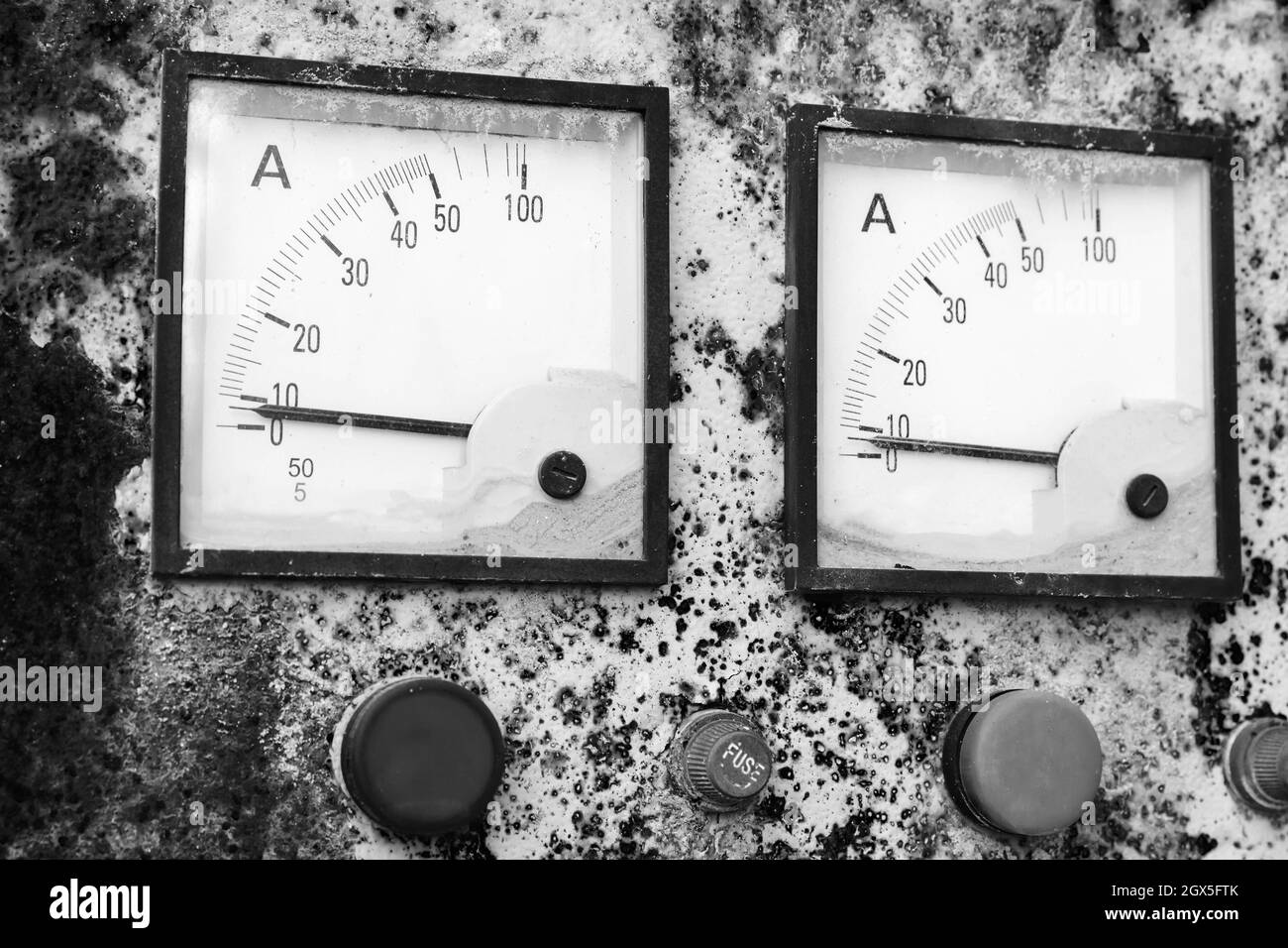 Two industrial square ammeters show zero power level, close up photo of a rusty old electric control panel. Vintage stylized black and white photo Stock Photo
