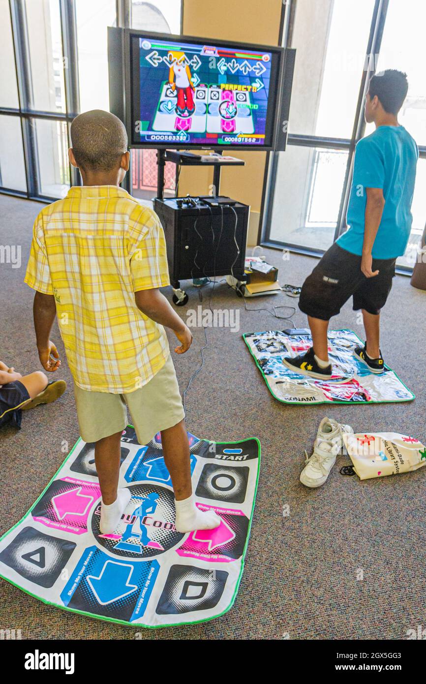 Miami Florida,Cultural Center Plaza,Main Public Library,Dance Revolution DDR video game,Hispanic Black boys interactive exercise physical activity Stock Photo